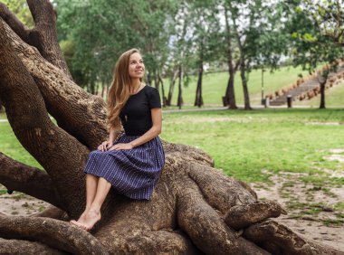 Ağaç üzerinde oturan güzel kız 