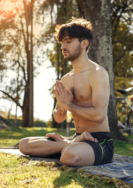 Genç adam lotus duruş parkta meditasyon
