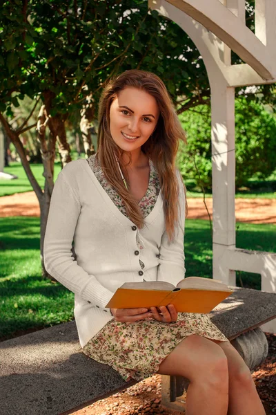 Güzel öğrenci kız parkta okuma