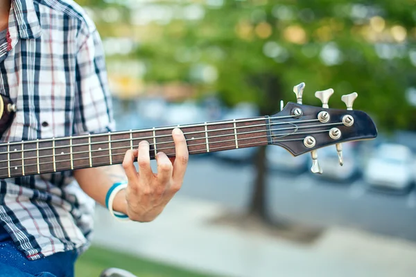 Elini bir akustik bas gitar ile