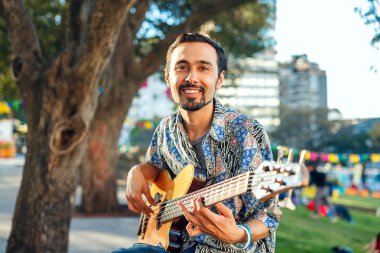 Adam kutlama açık havada gitarda ile gülümseyen