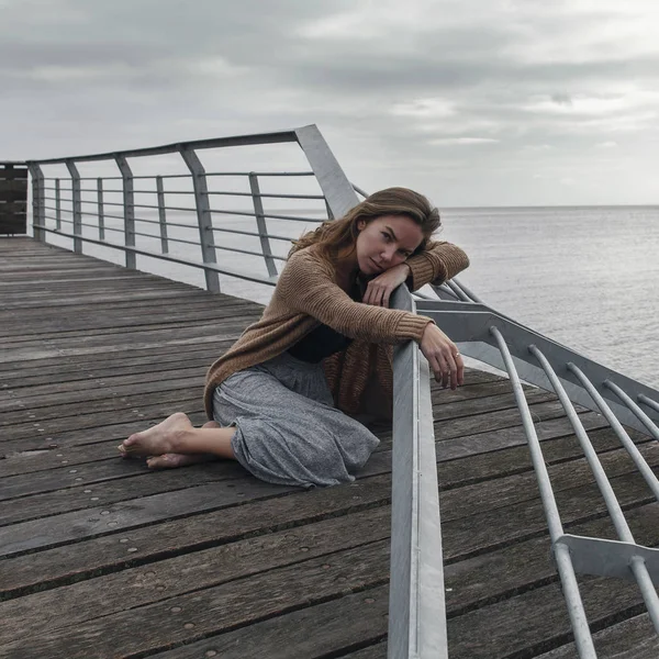 Eski yatak üzerinde oturan üzgün kız 