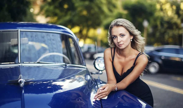 Mavi eski model araba ile zarif sarışın kadın