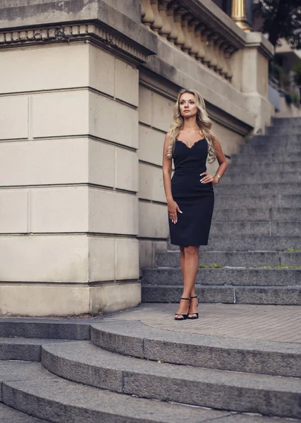 Élégante jeune femme debout sur de beaux escaliers à l'extérieur — Photo