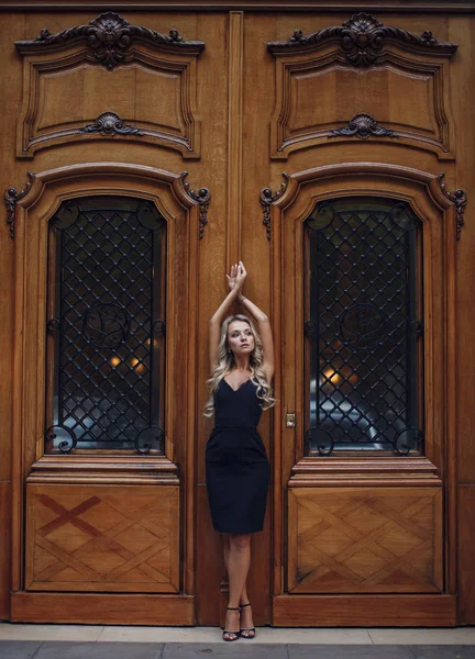 Belle femme debout dans la pose de grâce près des portes vintage — Photo