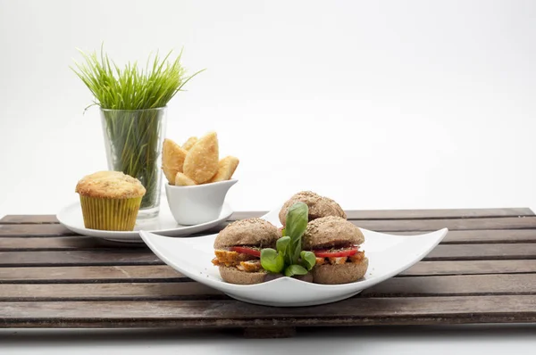 Mini tavuklu sandviç, domates, fesleğen, catering, olaylar ve parti için beyaz tabakta zeytin