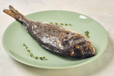 Yeşil tabakta fırında Dorado balığı