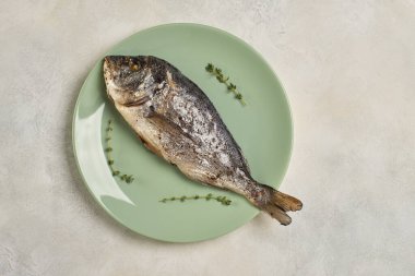 Yeşil tabakta fırında Dorado balığı