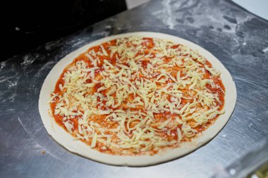 Mutfaktaki şef pizza hazırlıyor.