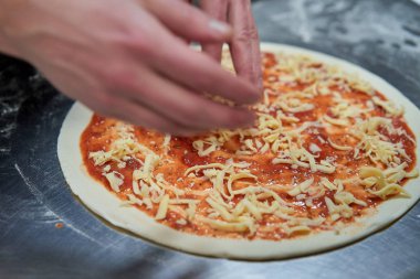 Mutfaktaki şef pizza hazırlıyor.