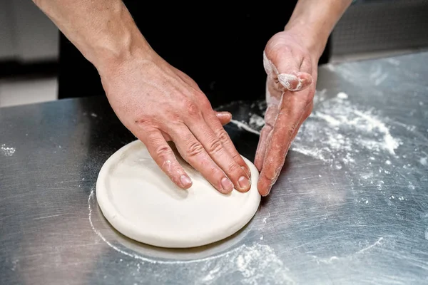 Der Koch in der Küche bereitet Pizza zu — Stockfoto