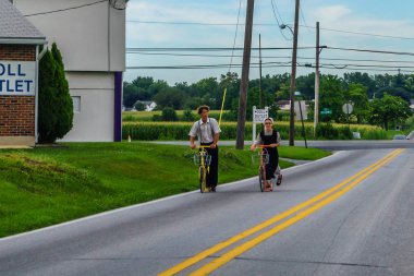 Ronks, Amish ülke, Pa 27 Julay 2017 bir erkek ve bir kadın üzerinde amish stil scooter sürme