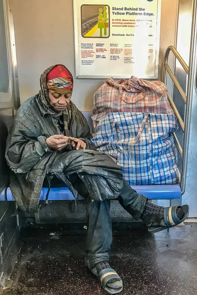 Manhattan, NY US - March 19, 2018 Homeless person sits in a subway car — Stock Photo, Image