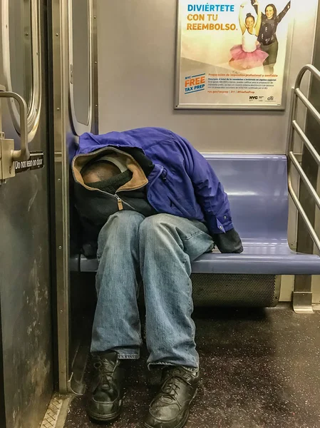 Manhattan, NY US - February 26, 2018 Homeless person sleeps in a subway car — Stock Photo, Image