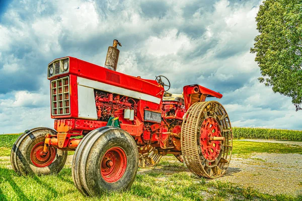 Amish country vintage tractor agrícola rojo con ruedas de metal sobre un fondo de campo en Lancaster, PA US — Foto de Stock