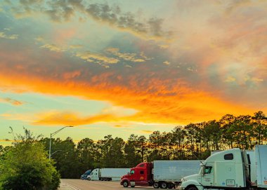 Gürcistan, ABD - 5 Eylül 2019 Gürcistan Ziyaretçi Merkezi ve dinlenme alanı yaz günbatımının arka planına karşı gökyüzünde beyaz, turuncu, mavi ve koyu bulutlar ve ağır kamyonlar,