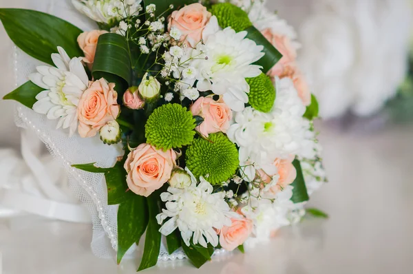 Buquê de casamento feito de rosas, crisântemo e deitado sobre a mesa — Fotografia de Stock