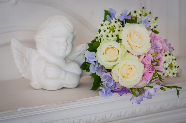 Ramo de boda hecho de rosas, hortensia, freesias con ángel de pie cerca — Foto de Stock