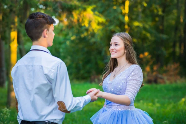 Un couple d'histoire d'amour, amoureux, ensemble dans le parc forestier, fille dans une belle robe violette, soirée ensoleillée, été, tournage de mariage thématique, robe à volants — Photo