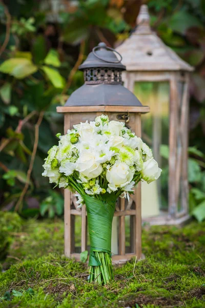 The wedding bouquet for the bride made of white roses and green chrysanthemum  Vintage wooden lantern and moss on the background — Stock Photo, Image