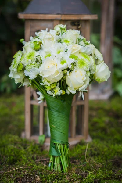 O buquê de casamento para a noiva feita de rosas brancas e crisântemo verde Vintage lanterna de madeira e musgo no fundo — Fotografia de Stock