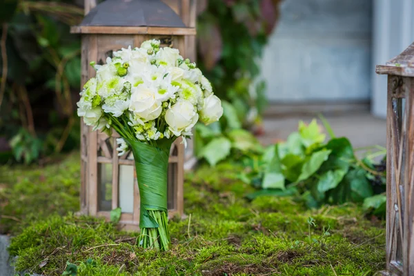 El ramo de boda para la novia hecha de rosas blancas y crisantemo verde Linterna de madera vintage y musgo en el fondo — Foto de Stock