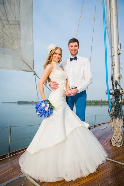 Boldog menyasszony és a vőlegény, átölelve egy jachton — Stock Fotó