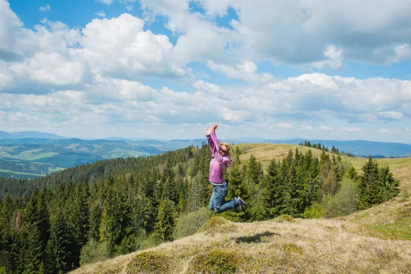 yüksek dağlar mavi gökyüzü ve beyaz bulutlar üzerinde arka plan atlama bir kadın. mutlu atlama. yüksek dağlarda