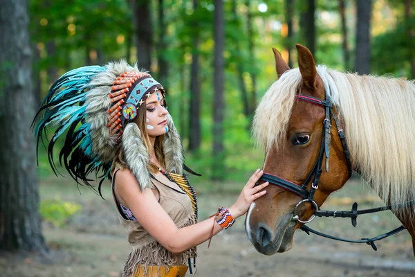 Bella ragazza in un vestito della donna indiana americana nello scarafaggio con il cavallo Fotografia Stock