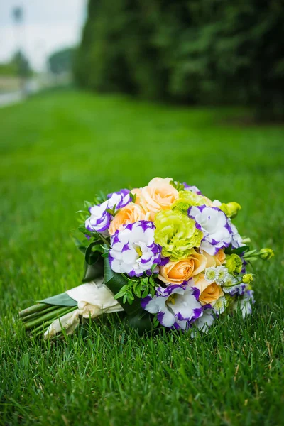 Bouquet da sposa sull'erba verde, madd da rose ed eustoma - colori arancio e voilet — Foto Stock