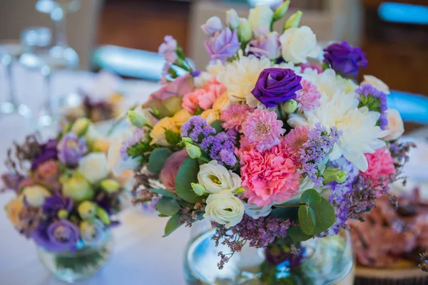 The decoration for the wedding table - violet flowers in the transparent vase — Stock Photo, Image