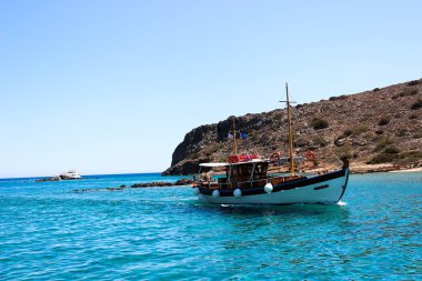 Fotoğraf mavi denizde yelkenli bir gemi gösteriyor