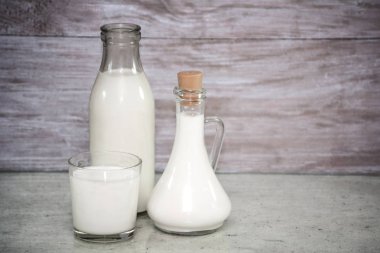 Bir bardak süt. bir cam sürahi, şişe süt ahşap arka plan üzerinde süt. Alfaphotorus kavram