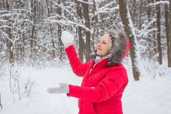 Senior gumman kastar snöboll i trä i röd kappa — Stockfoto