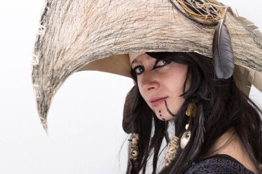 Siyah tüyleri ve beyaz arka plan gölgeler ile karga kafasına cadı ya da şaman halloween Kostüm giymiş güzel kız