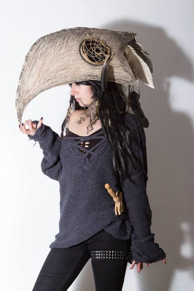 Siyah tüyleri ve beyaz arka plan gölgeler ile karga kafasına cadı ya da şaman halloween Kostüm giymiş güzel kız