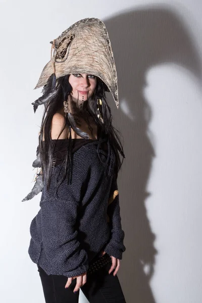 Siyah tüyleri ve beyaz arka plan gölgeler ile karga kafasına cadı ya da şaman halloween Kostüm giymiş güzel kız