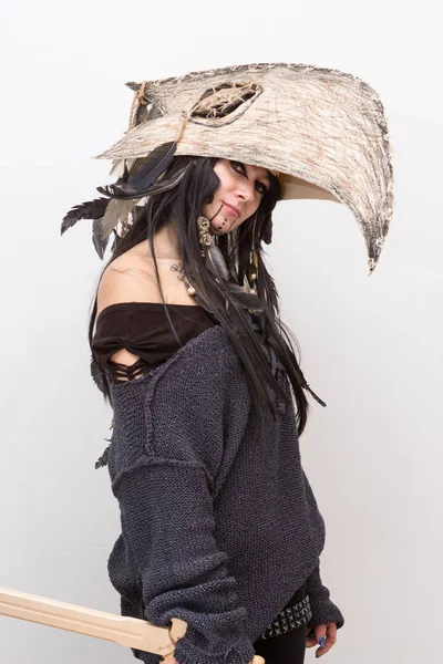 Siyah tüyleri ve beyaz arka plan gölgeler ile karga kafasına cadı ya da şaman halloween Kostüm giymiş güzel kız