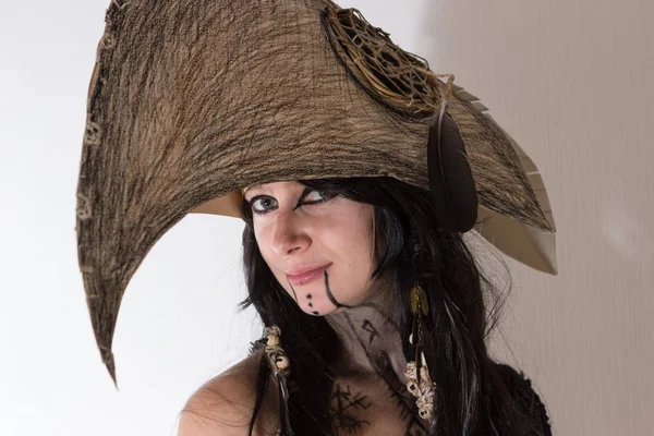 Siyah tüyleri ve beyaz arka plan gölgeler ile karga kafasına cadı ya da şaman halloween Kostüm giymiş güzel kız