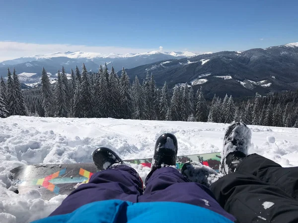 Dağlarda Kayak rapor üzerinde boş zaman tatil. Bacaklar çift erkek ve kız güzel kar dağlar önünde görüntülemek.