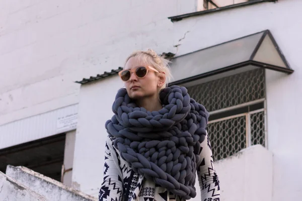 Aztek siyah ve beyaz ceket ve gri yelek örme eşarp giyen kız sarışın genç güzel moda. Festival kıyafeti. Yaşam tarzı sokak moda trendi