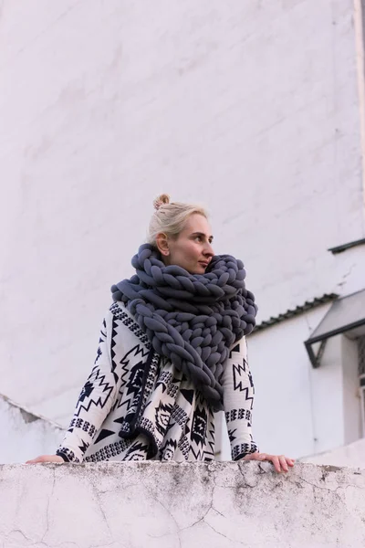 Aztek siyah ve beyaz ceket ve gri yelek örme eşarp giyen kız sarışın genç güzel moda. Festival kıyafeti. Yaşam tarzı sokak moda trendi