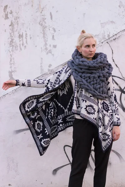 Aztek siyah ve beyaz ceket ve gri yelek örme eşarp giyen kız sarışın genç güzel moda. Festival kıyafeti. Yaşam tarzı sokak moda trendi