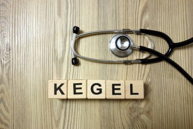 Ahşap arka planda steteskoplu Kegel kelimesi