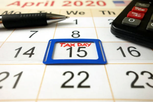 Μηνιαίο ημερολόγιο δείχνει την ημερομηνία 15 Απριλίου 2020 σημειώνονται ως φορολογική ημέρα με στυλό και αριθμομηχανή — Φωτογραφία Αρχείου