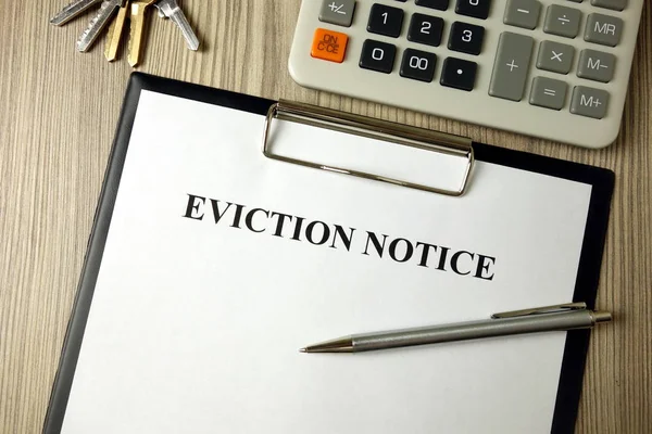 Home eviction notice legal document with pen calculator and keys