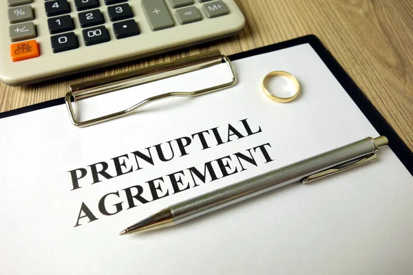 Prenuptial agreement with pen calculator and wedding ring — Stock Photo, Image