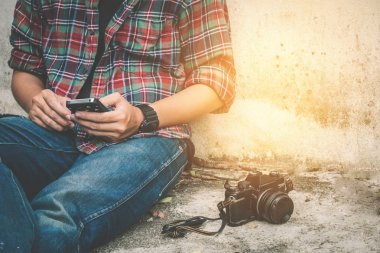 Genç adam kullanarak cep telefonu eski retro kamera ile