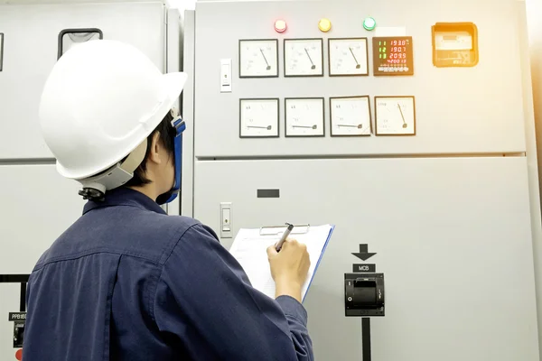 Technician is recording data Voltage or current in control panel — Stock Photo, Image