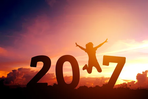 Silhouette ung kvinna hoppa till 2017 nyår — Stockfoto